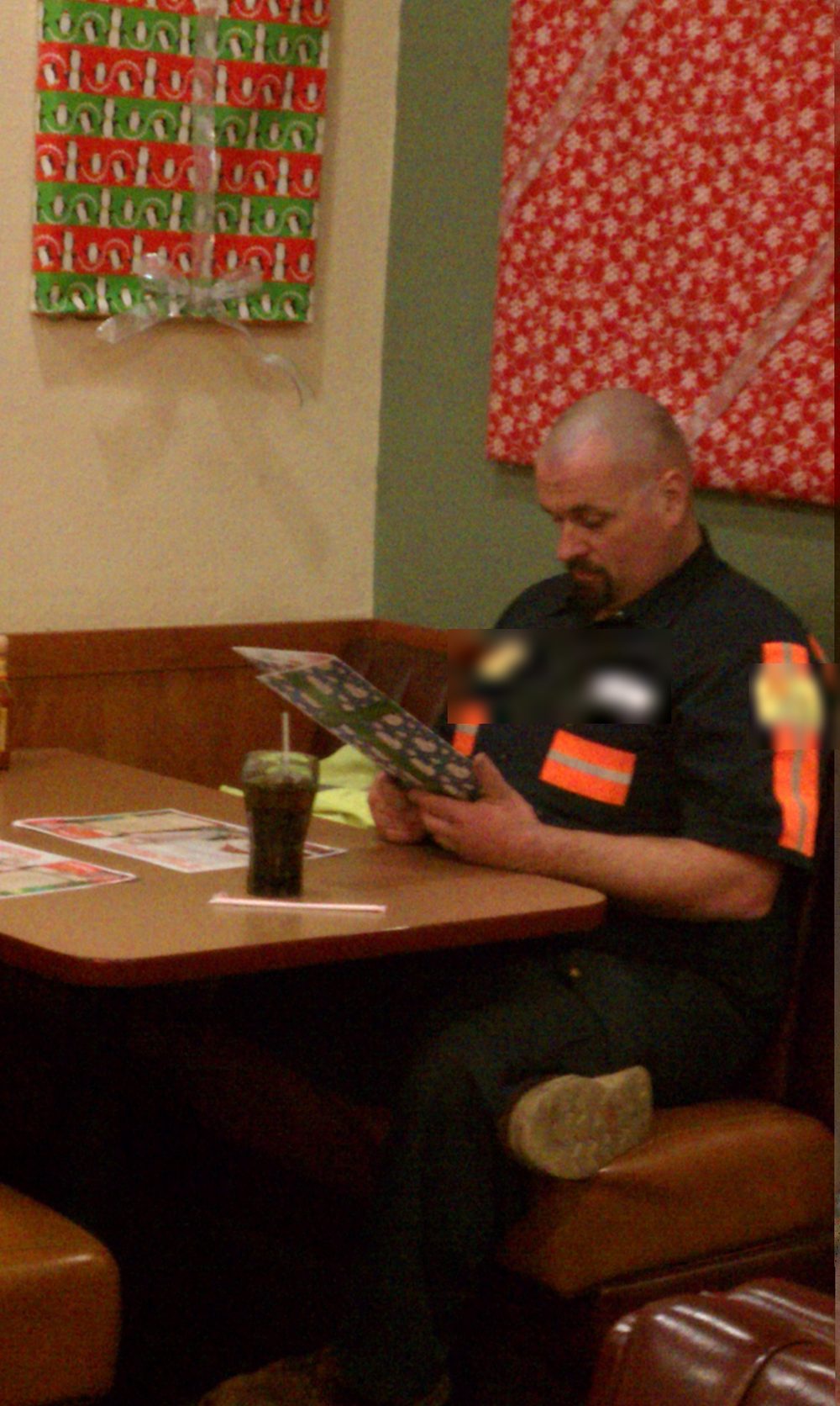 Candid photo of the swamp donkey in his natural habitat: a diner booth, studying the menu.